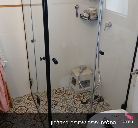 מקלחון עם מוצרי טיפוח וכלים על הרצפה